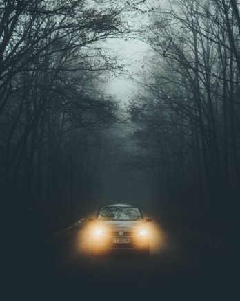 A car with its lights on in the fog